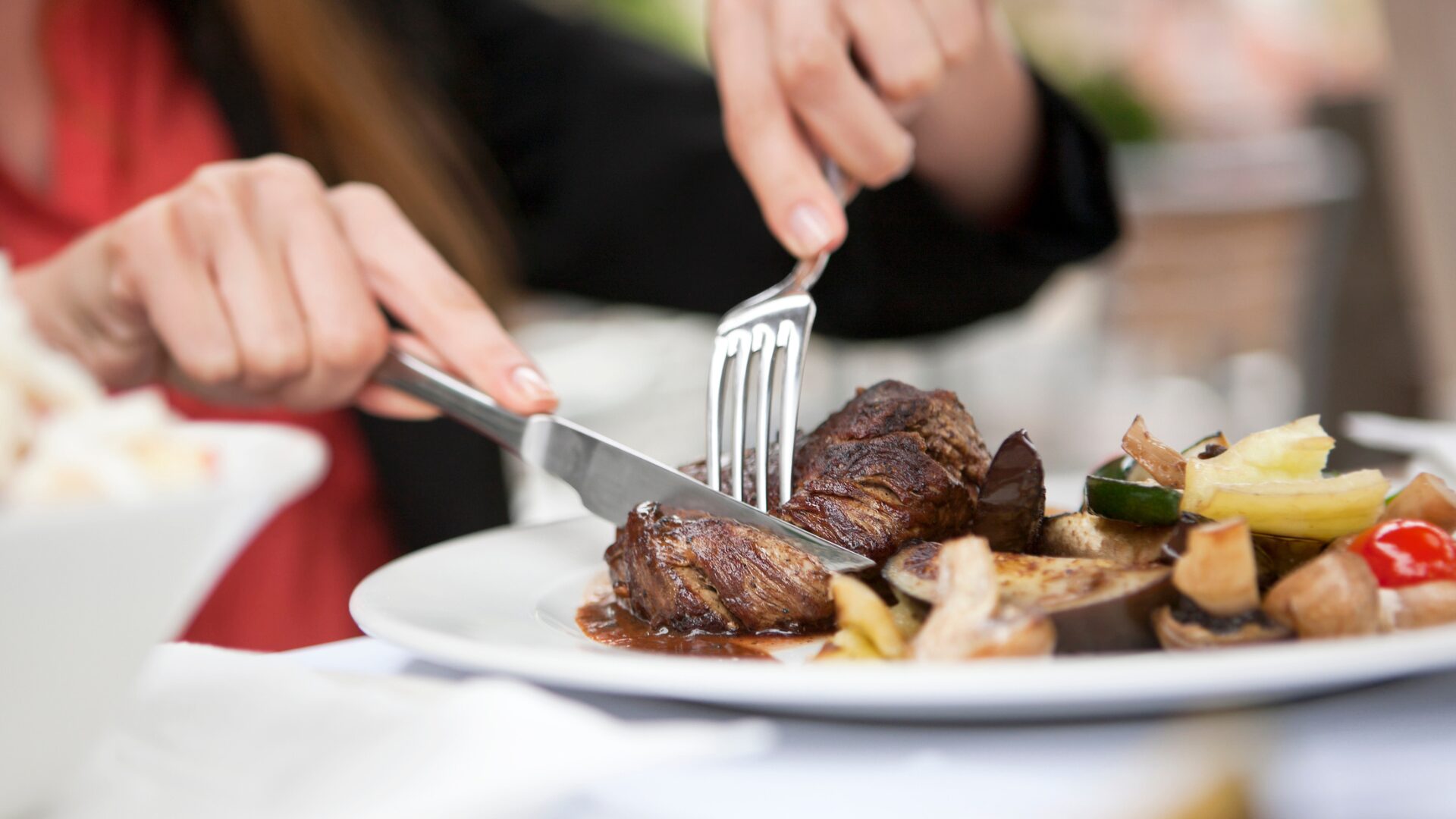 Meat-focused dinner. Someone eating Steak